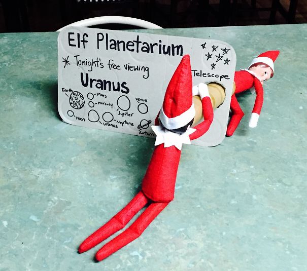 "Elf On The Shelf idea with elves setting up an 'Elf Planetarium' with a sign for viewing 'Uranus,' humorously looking through a telescope."