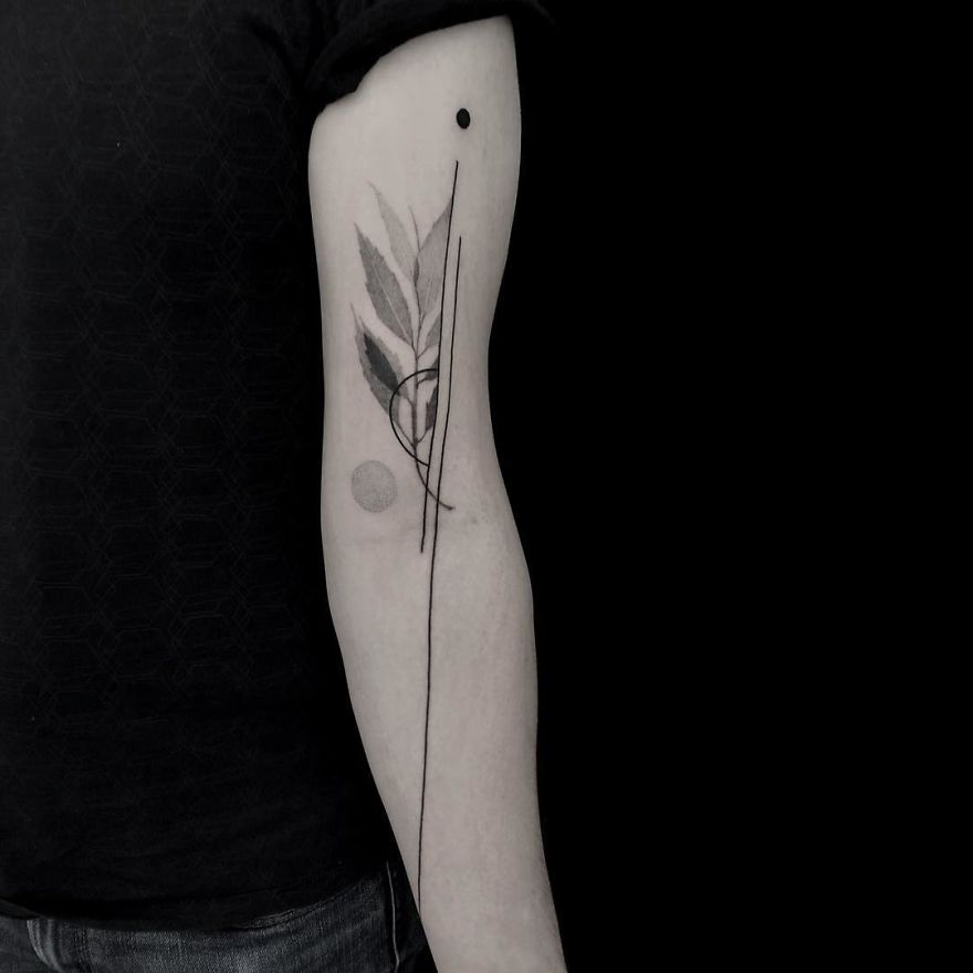 Minimalist tattoo with botanical illustration on a person's forearm in black ink.