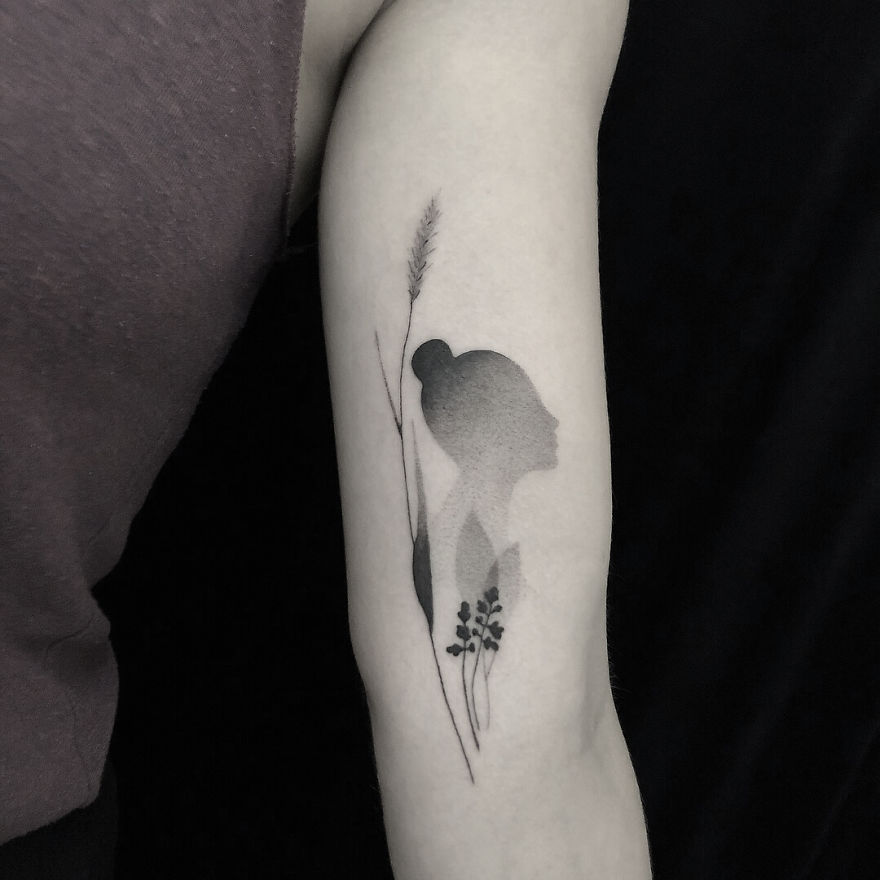Minimalist tattoo featuring botanical illustrations on an arm.