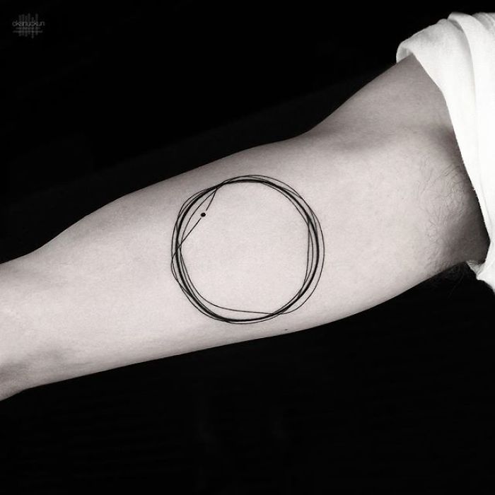 Geometric tattoo by Turkish artist Okan Uçkun featuring overlapping circular lines on an arm.