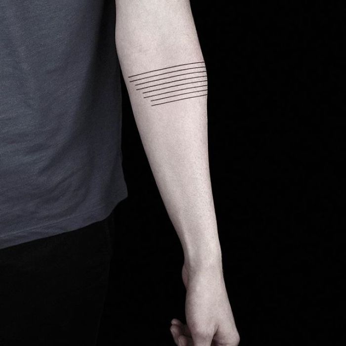 Geometric tattoo with parallel lines on a forearm by Turkish artist.