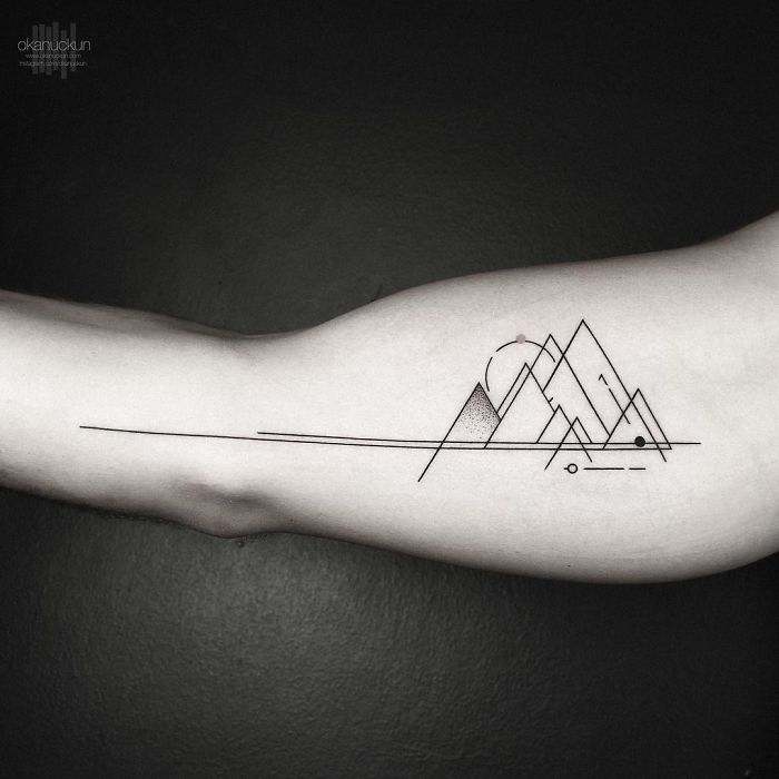 Geometric tattoo of abstract mountains and lines on arm, created by Turkish artist Okan Uçkun.