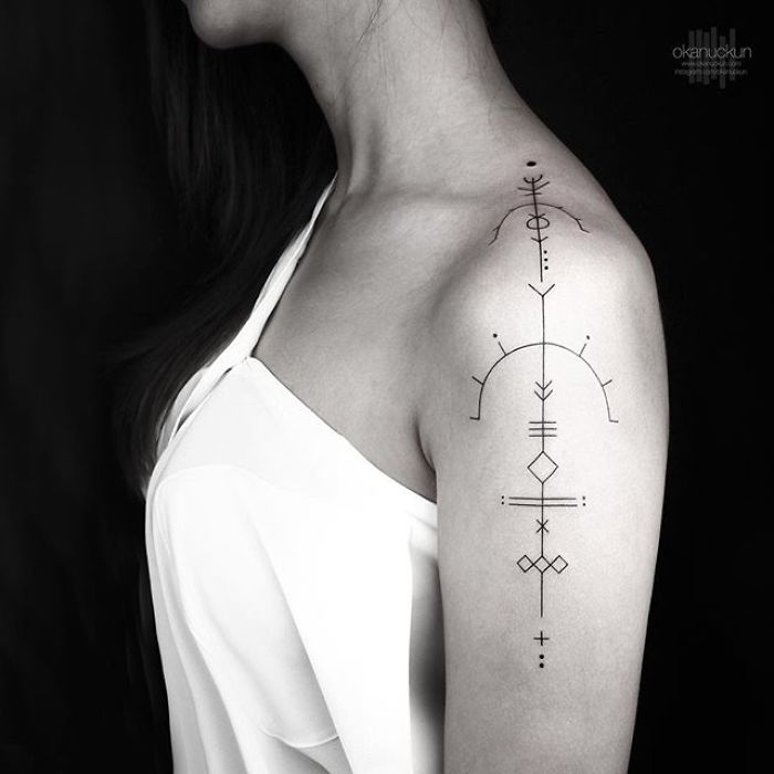 Geometric tattoo on arm featuring intricate linear designs by Turkish artist Okan Uçkun.