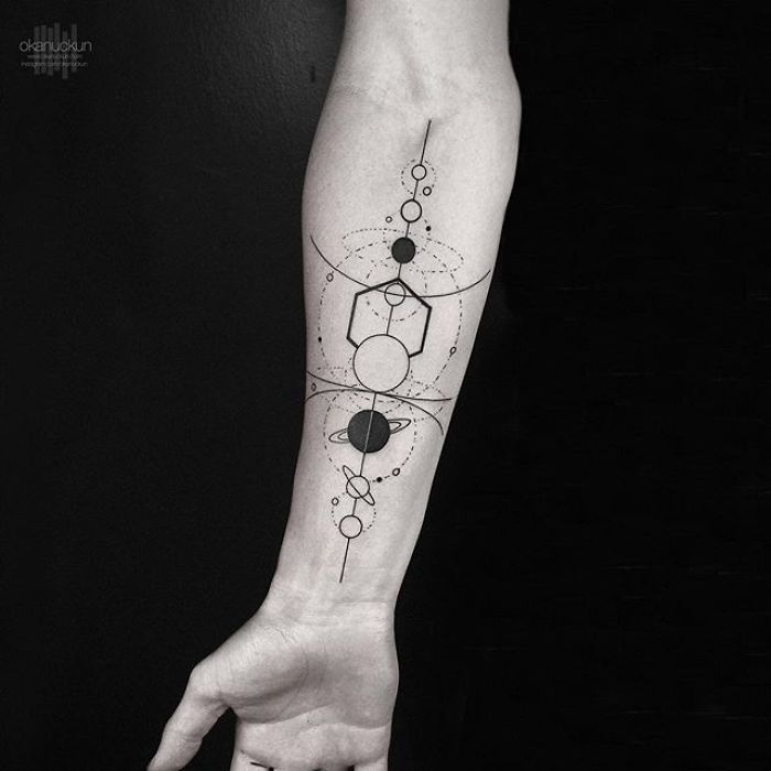 Geometric tattoo featuring circles and lines on a forearm by Turkish artist Okan Uçkun.