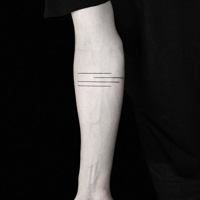 Minimalist geometric tattoo by Turkish artist on forearm, featuring parallel lines.