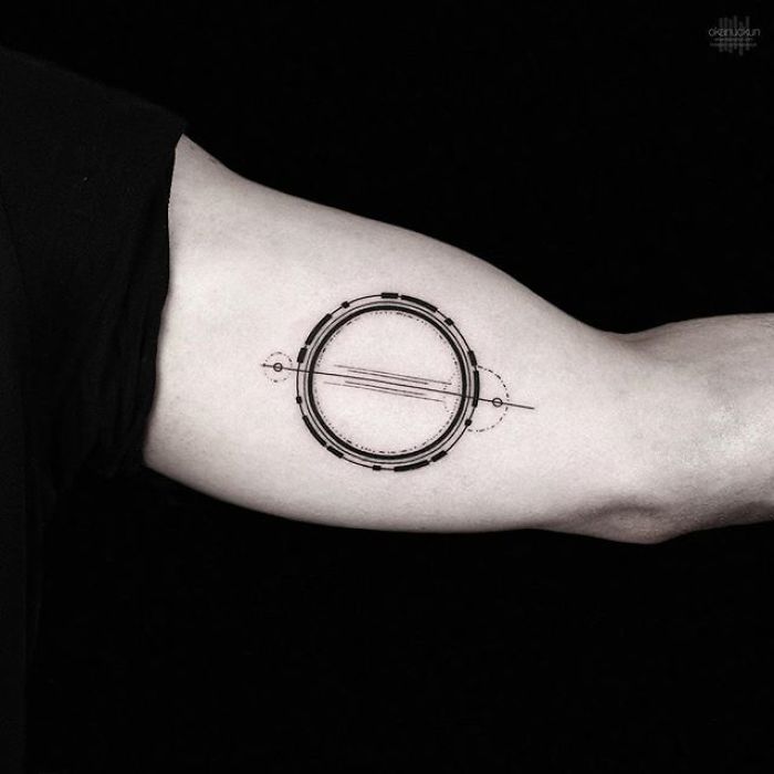 Geometric tattoo by Turkish artist Okan Uçkun, featuring a circle with intricate lines on a person's forearm.