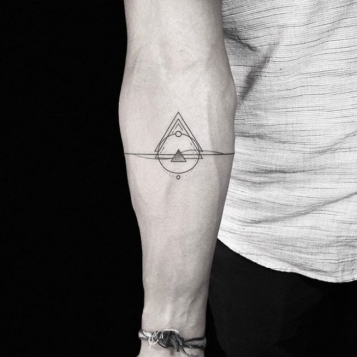 Geometric tattoo on forearm by Turkish artist, featuring a triangle and circle design.
