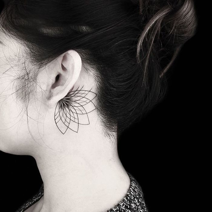 Geometric tattoo behind the ear by Turkish artist, featuring delicate line work in a modern design.