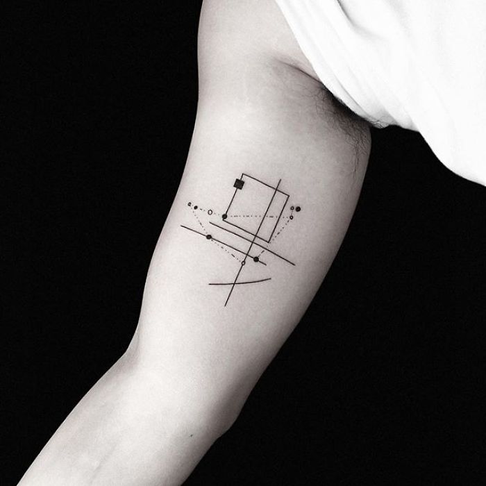 Geometric tattoo on arm by Turkish artist Okan Uçkun, featuring lines, dots, and a square design.