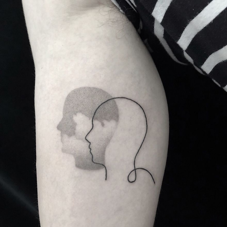 Minimalist tattoo with botanical-inspired silhouette on an arm.