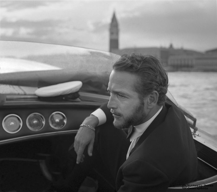 Black and white photo of a celebrity relaxing on a boat in Venice, showcasing rare vintage celebrity moments in the 50s and 60s.