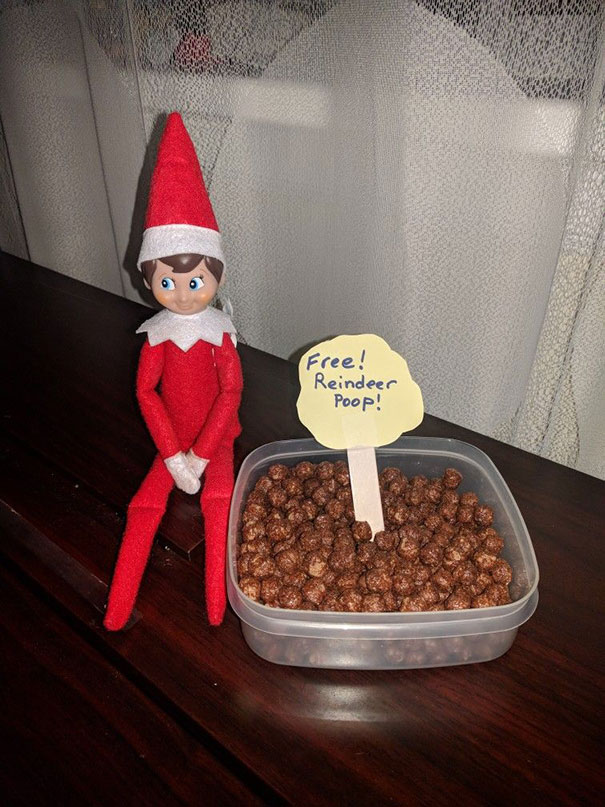 "Elf On The Shelf idea with elf next to a container labeled 'Free! Reindeer P**p!' filled with cocoa cereal, creating a playful scene."