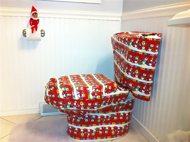 "Elf On The Shelf idea with the elf perched on a toilet paper holder, while the entire toilet is wrapped in festive holiday gift wrap."