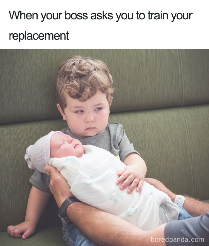 Little boy looking skeptical while holding a baby, illustrating a funny coworker meme scenario.
