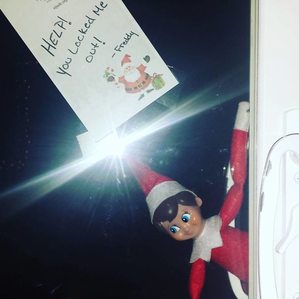 "Elf On The Shelf idea with elf peeking through a door window, holding a note that reads, 'HELP! You locked me out!' for a playful scene."
