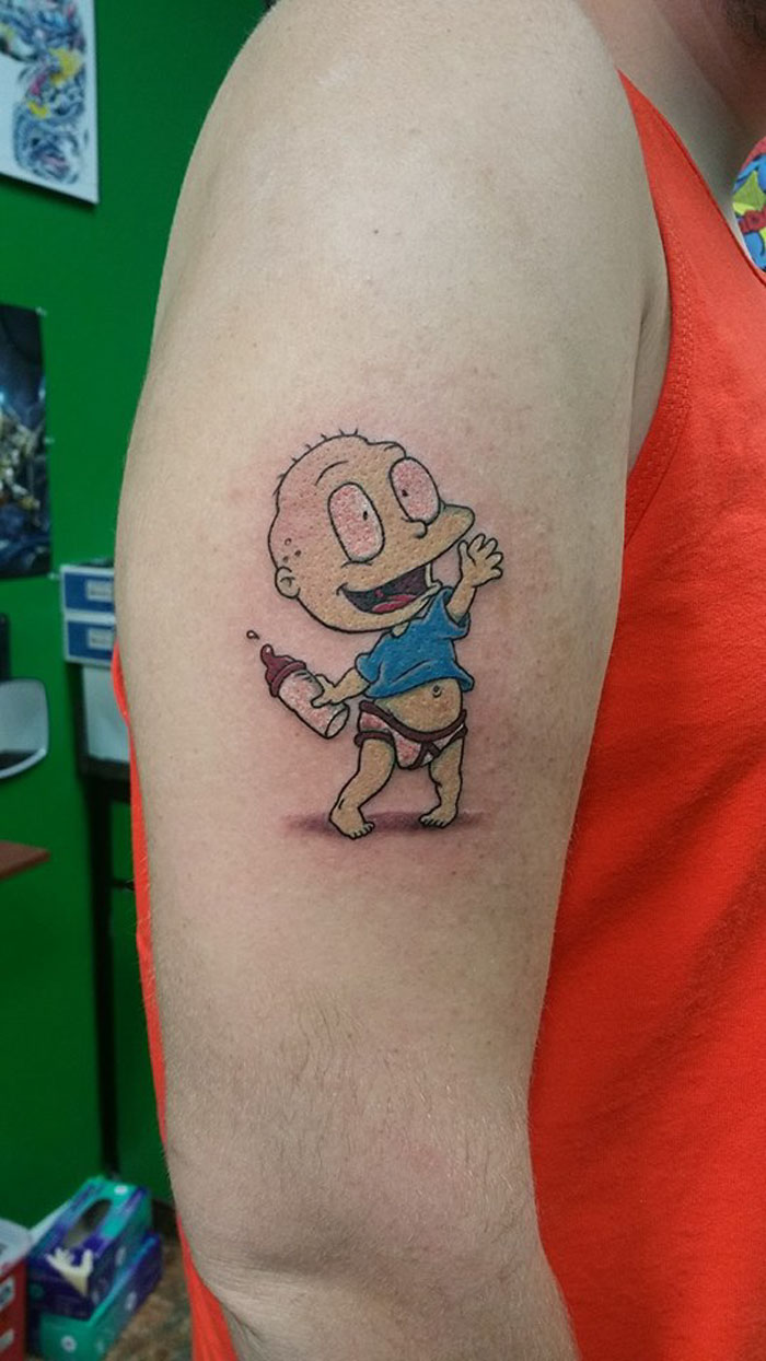 Tattoo of cartoon character on an autistic man's arm wearing an orange top in a tattoo studio. Tattoo of cartoon character on an autistic man's arm wearing an orange top in a tattoo studio.