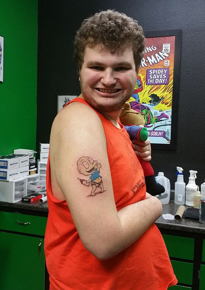 Autistic man smiling proudly with his new tattoo in a tattoo shop. Autistic man smiling proudly with his new tattoo in a tattoo shop.