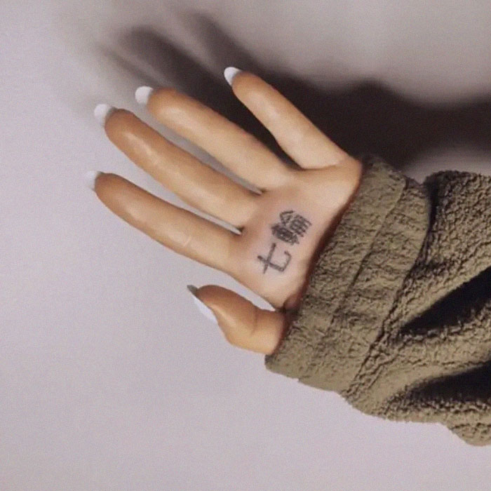 Hand with Japanese BBQ tattoo attempt, covered in a cozy green sleeve.