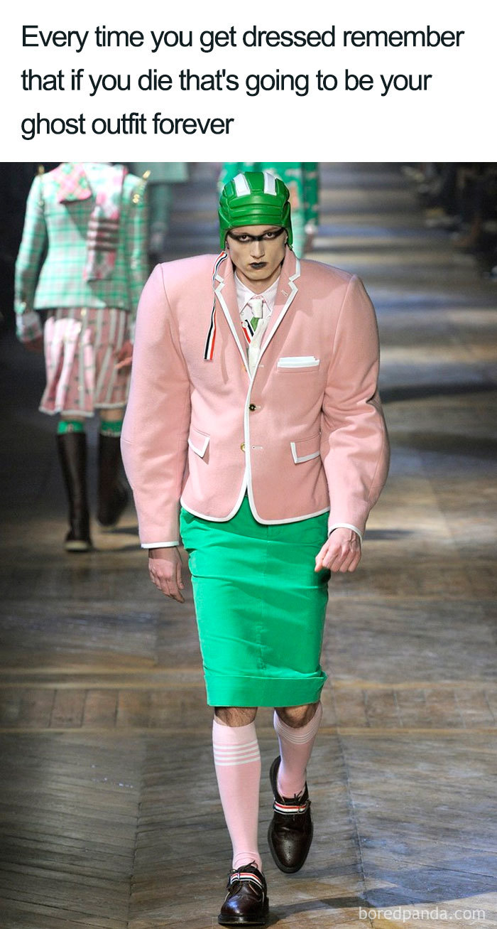 Model on runway in pink blazer and green skirt, showcasing a fashion disaster turned into a meme.