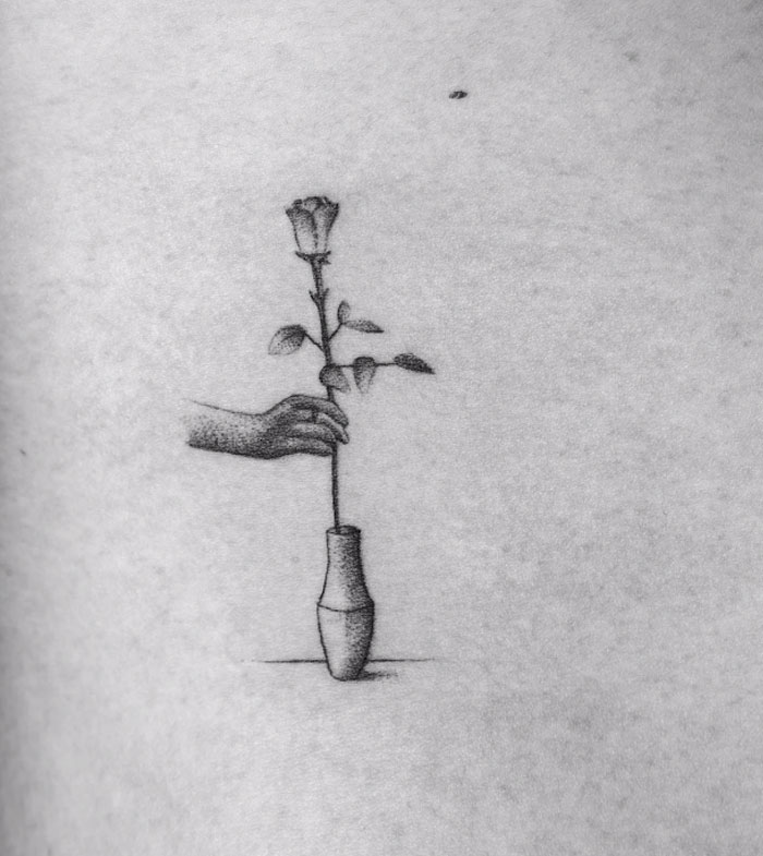 Tattoo of a hand placing a rose in a vase, part of a motion tattoo project involving 70 frames. Tattoo of a hand placing a rose in a vase, part of a motion tattoo project involving 70 frames.