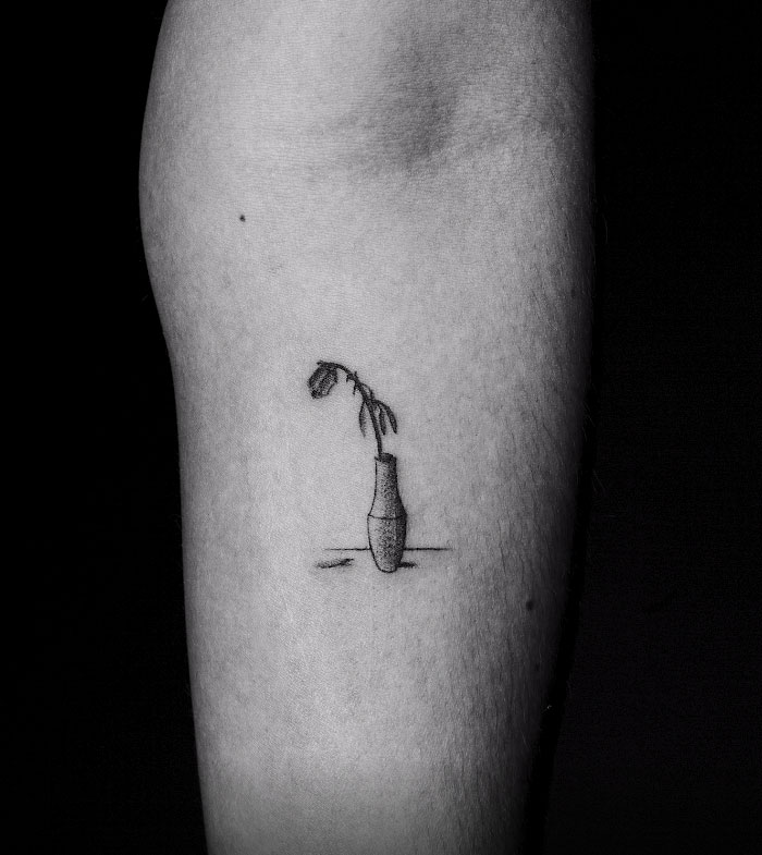 Tattoo of a wilted flower in a vase on skin, part of artist's motion tattoo project. Tattoo of a wilted flower in a vase on skin, part of artist's motion tattoo project.