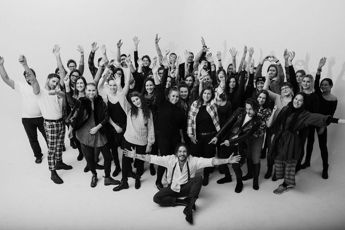 Group of 70 strangers posing together, each with a unique frame of a motion tattoo.