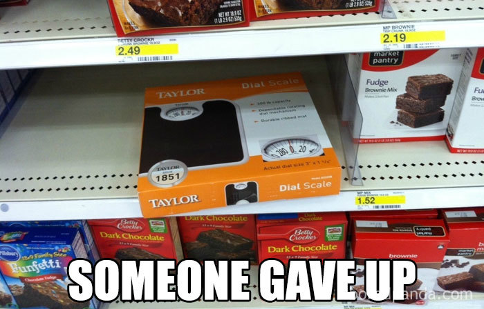 Dial scale in brownie aisle with text "Someone gave up" humorously depicting weight loss and diet theme.