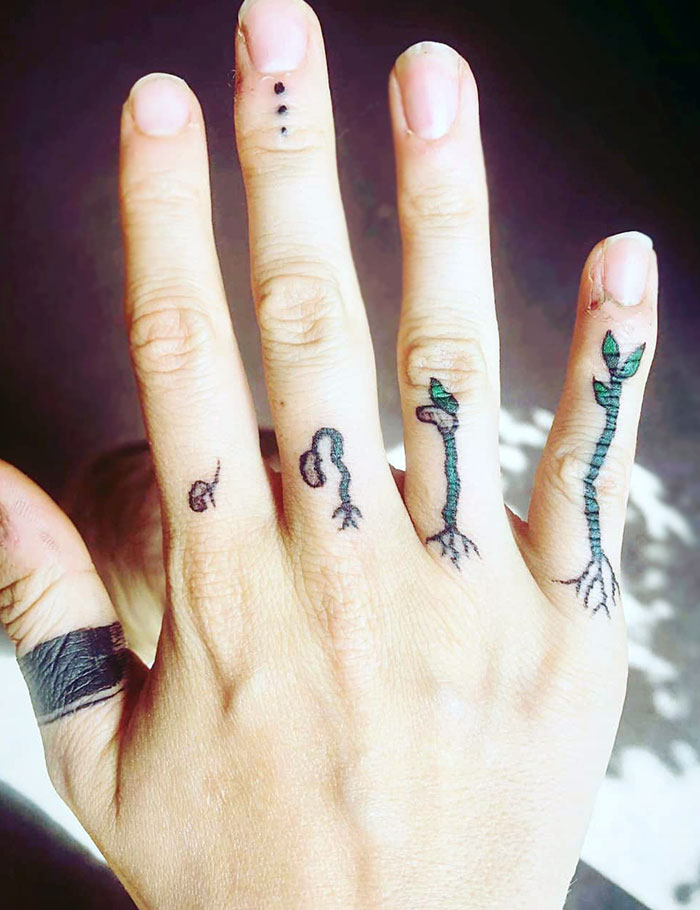 Finger tattoos of plant sprouts on a hand, showcasing the newest trend in body art design.