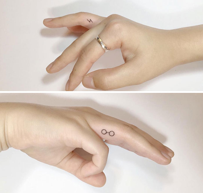 Minimalist finger tattoos with lightning bolt and glasses design, showcasing the latest trend in tattoo art.