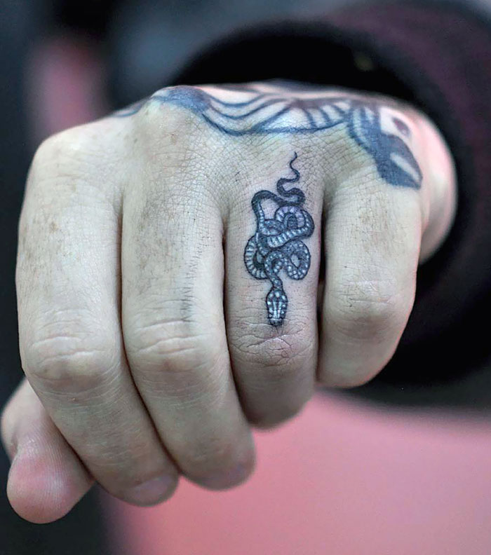 Snake design on a finger tattoo, showcasing the newest trend in body art.