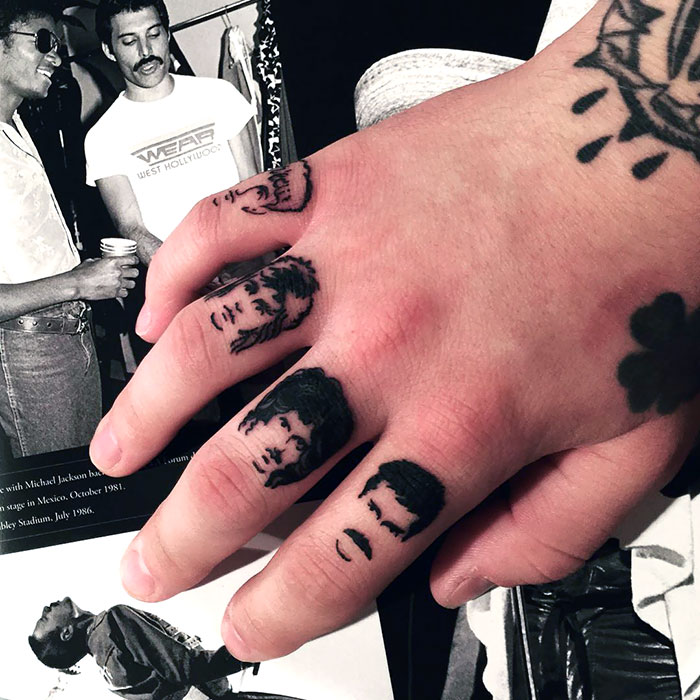 Close-up of unique finger tattoos featuring various portraits, showcasing the latest trend in finger tattoos.
