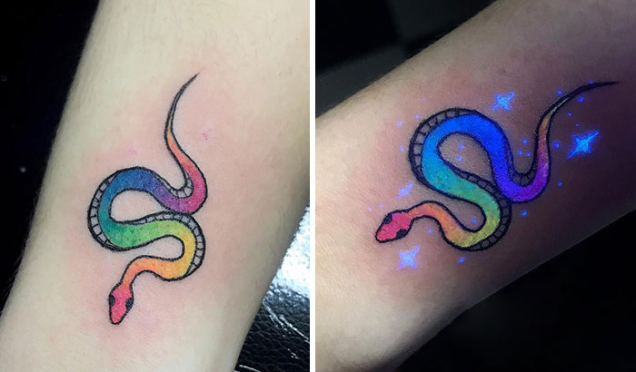 Colorful UV tattoo of a snake glowing under black light.