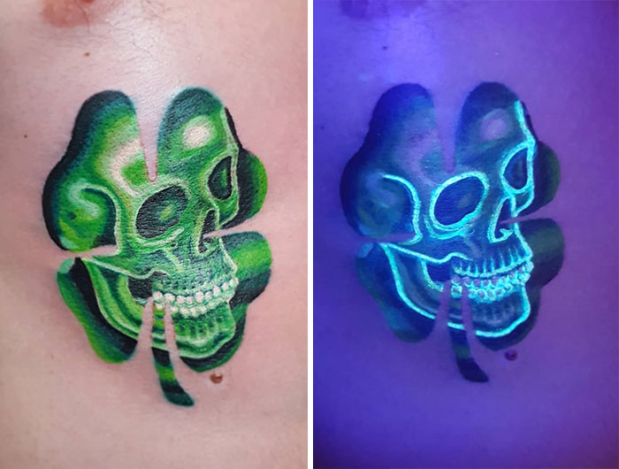 UV tattoo design of a green skull and clover on skin, glowing under blacklight.