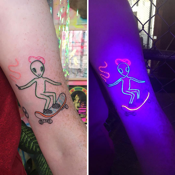 Alien skater UV tattoo glowing under blacklight, enhancing the design's vibrant colors.