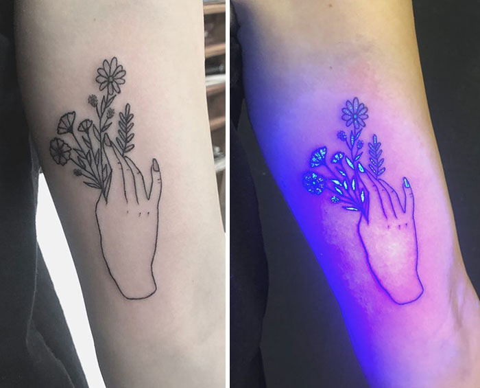 UV tattoo of a hand holding flowers, glowing under blacklight to showcase intricate design details.