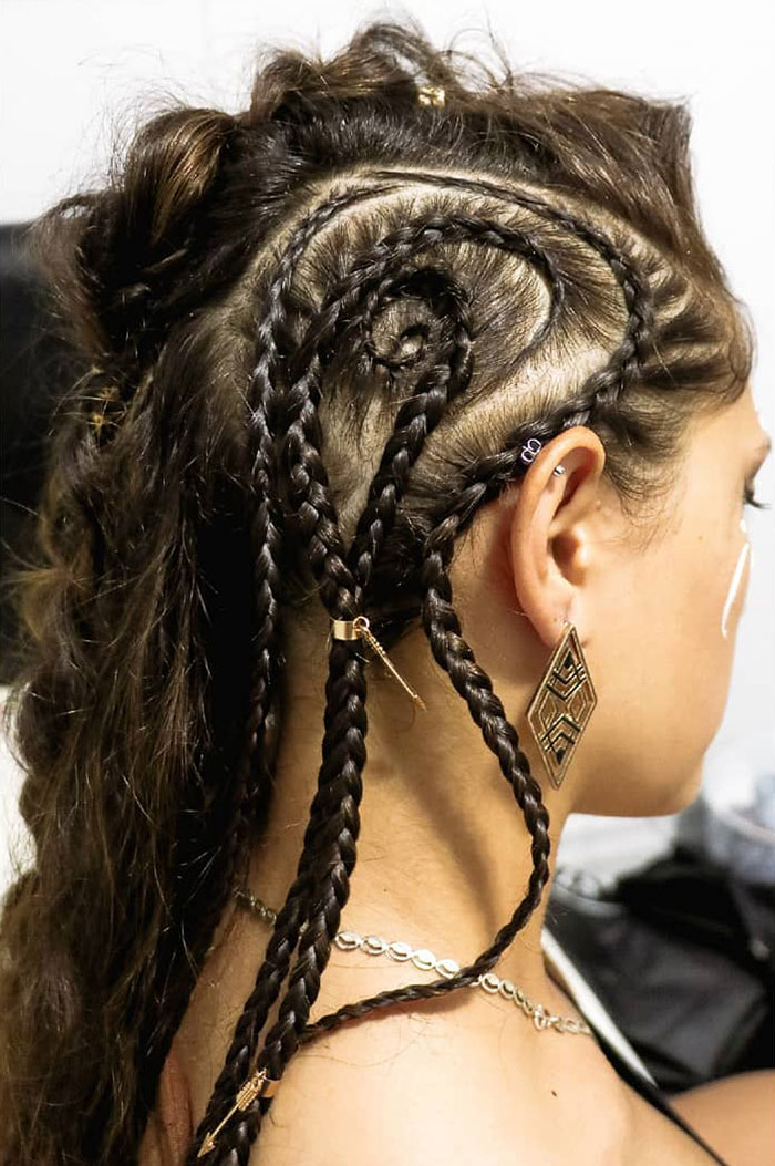 Intricate Viking hairstyle with braided patterns for modern-day Valkyries, featuring ornate earrings and detailed braids.
