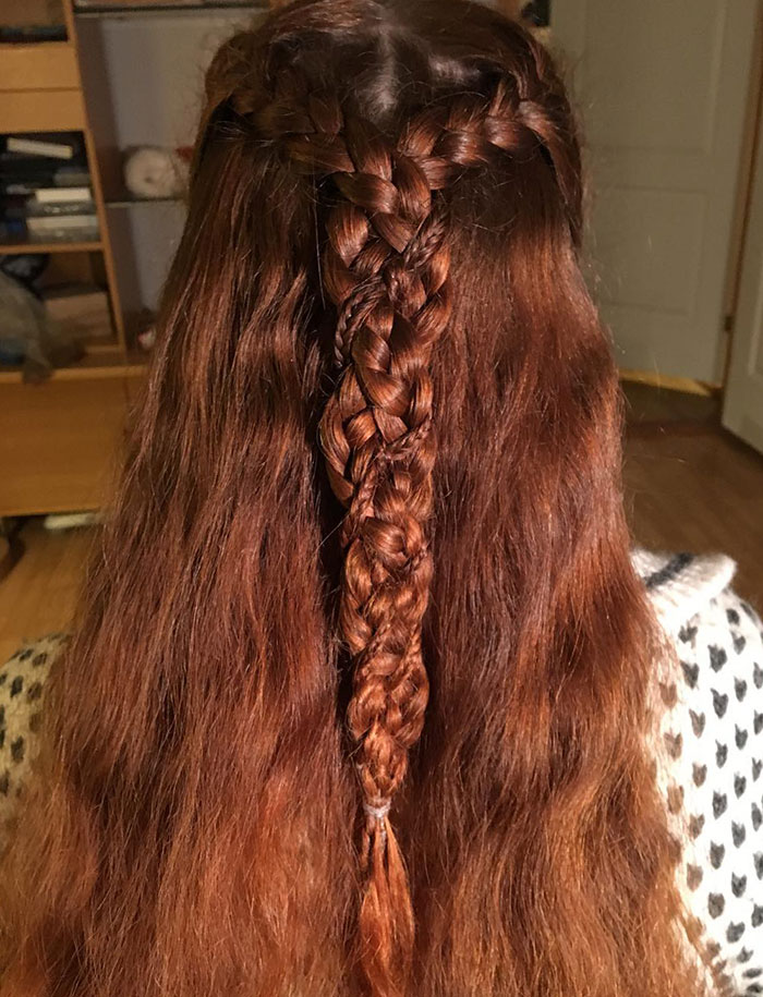 Intricate Viking braid hairstyle on long, reddish-brown hair.