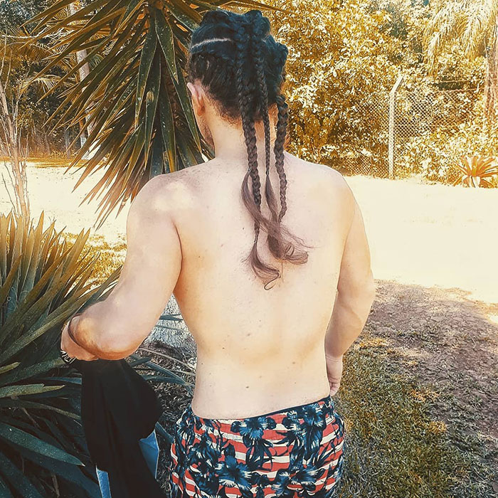 Back view of a person with fierce Viking braids, in a tropical setting.
