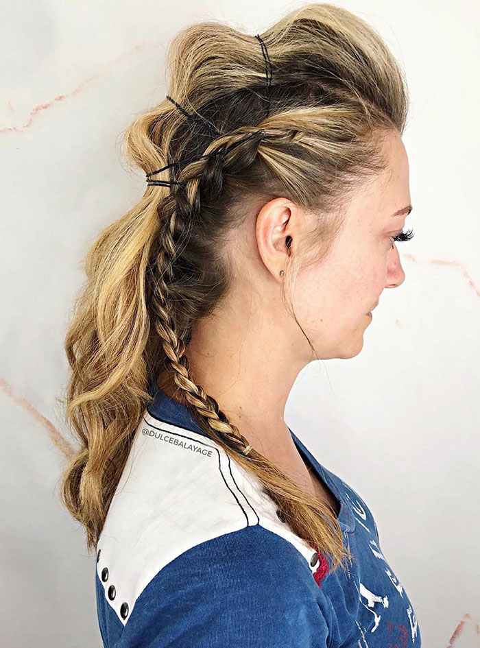 Woman with fierce Viking hairstyle featuring braids, wearing a blue shirt.