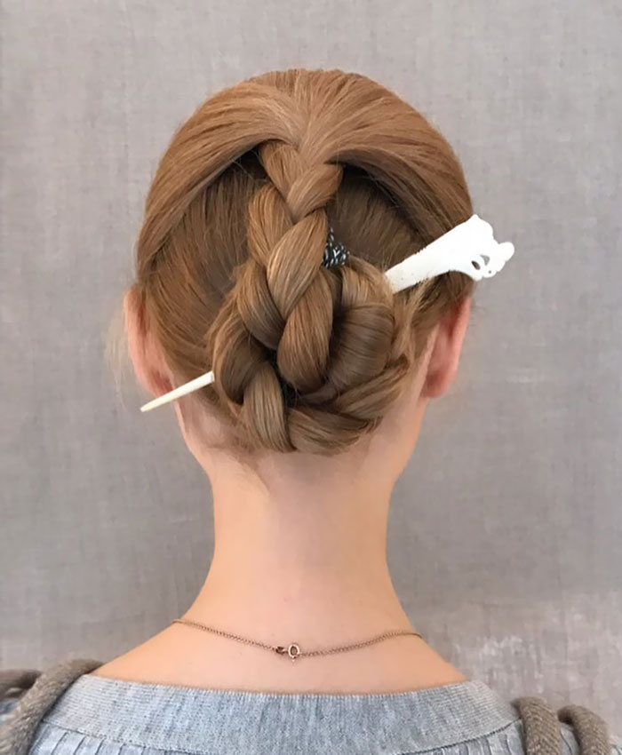 Braided Viking hairstyle with a hairpin, showcasing intricate design for modern day valkyries.