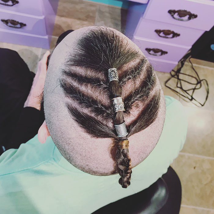 Viking hairstyle with intricate braids and silver bands, viewed from above, highlighting its fierce style.