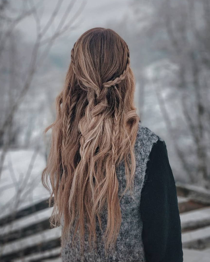 Long braided fierce Viking hairstyle on a woman with winter background.
