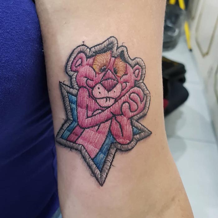 Embroidery tattoo of a cartoon character on a person's arm, showcasing Brazilian tattoo art style.