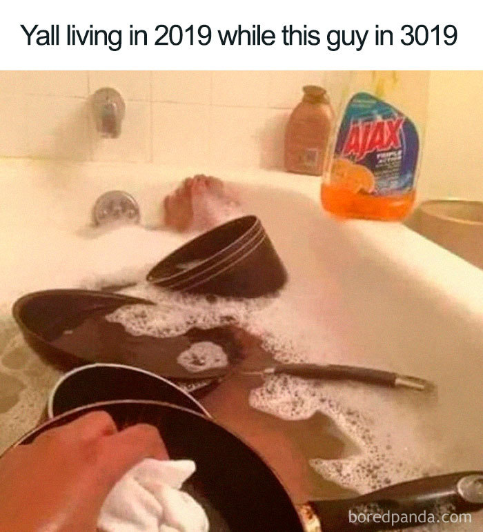 Person relaxing in a bathtub filled with dishes and soap, humorously representing a cleaning meme.