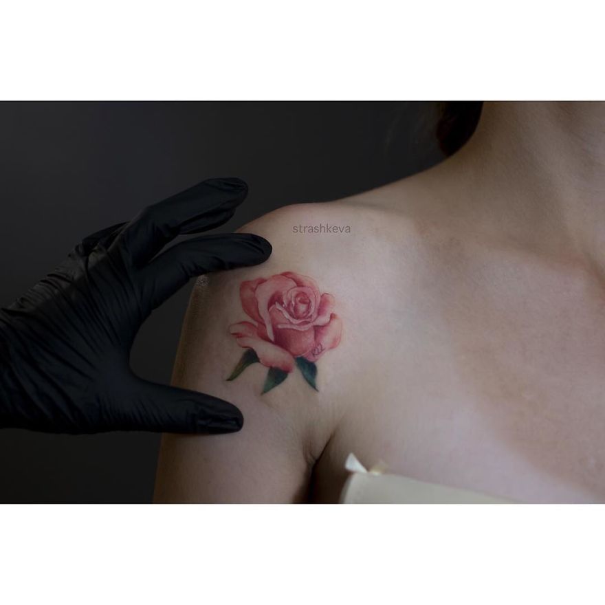 Tattoo artist from Lublin creating a realistic pink rose tattoo on a woman's shoulder.
