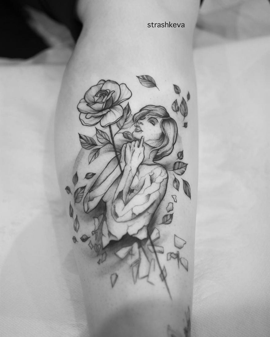 Tattoo by Lublin artist: a detailed black and gray design of a woman with a rose and scattered leaves.