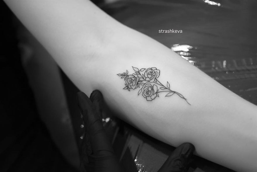 Delicate rose tattoo on an arm by Lublin artist, showcasing intricate floral design in black ink.