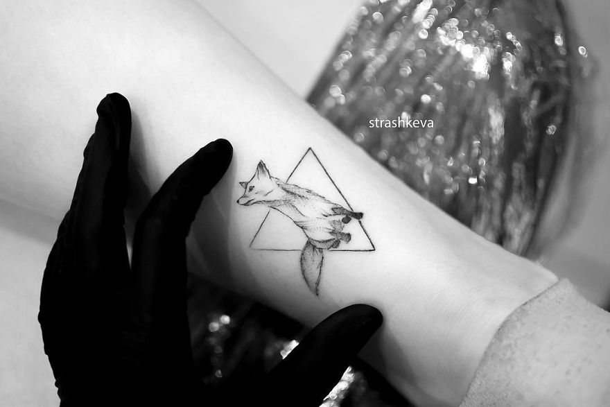 Tattoo of a fox inside a triangle on a person's arm by a Lublin tattoo artist.