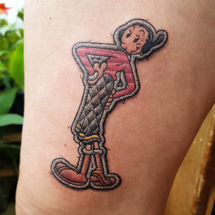 Embroidery tattoo of Olive Oyl in vibrant colors, showcasing the Brazilian tattoo artist's unique style.