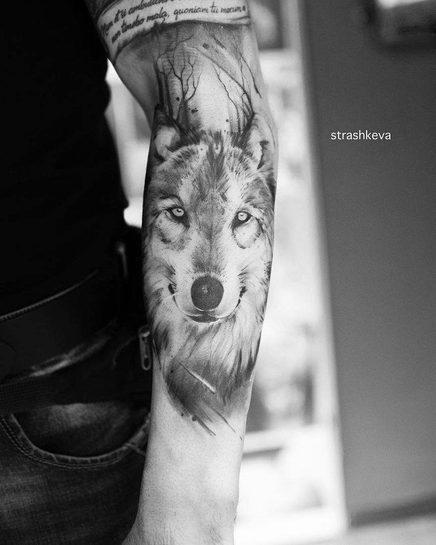 Black and white wolf tattoo on forearm by Lublin tattoo artist, showcasing intricate detail and artistry.